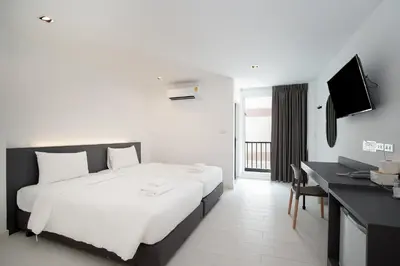 a hotel room with a bed and a desk and a television at The Urban Oasis in Bangkok