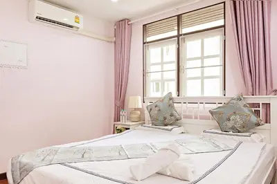 a bedroom with two beds and a window at Suttisan \u5730\u94c1\u53e3\u4e8c\u5c42\u72ec\u680b\u82b1\u56ed\u522b\u5885 \u4e94\u5367\u5ba4\u4e09\u536b in Bangkok