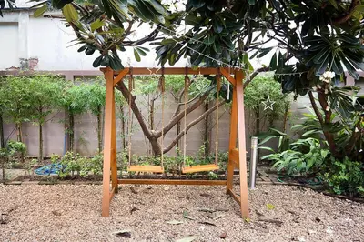 a wooden structure with benches in a garden at Suttisan \u5730\u94c1\u53e3\u4e8c\u5c42\u72ec\u680b\u82b1\u56ed\u522b\u5885 \u4e94\u5367\u5ba4\u4e09\u536b in Bangkok