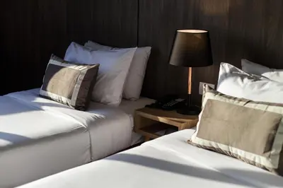 a hotel room with two beds and a lamp at Jazzotel Bangkok in Bangkok