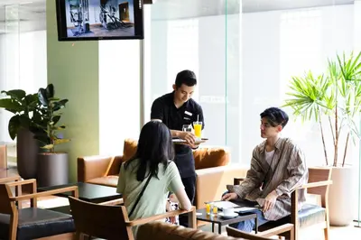 a group of people sitting around a table in a room at Jazzotel Bangkok in Bangkok