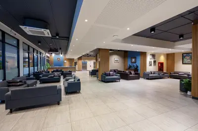 a lobby with couches and chairs in a building at Prom Hotel in Bangkok