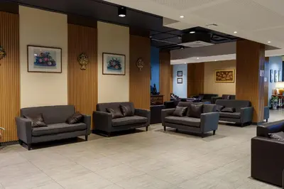 a waiting room with couches and chairs in a hospital at Prom Hotel in Bangkok