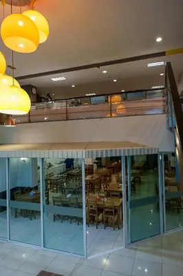 a view of a restaurant with tables and chairs at Prom Hotel in Bangkok