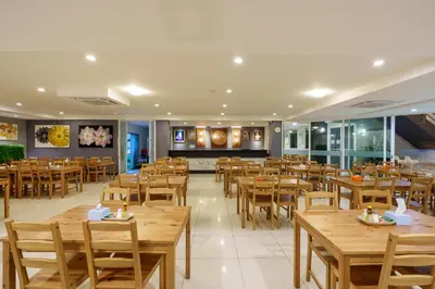 a dining room with wooden tables and chairs at Prom Hotel in Bangkok