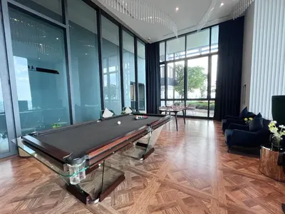 a pool table in a room with glass walls at Thanon Phaya in Bangkok