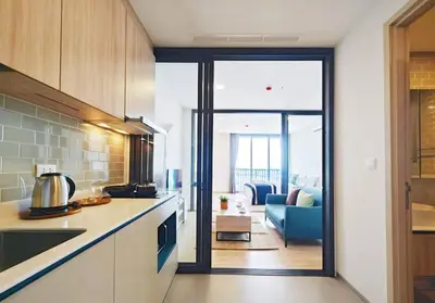 a kitchen with a view of a living room at Thanon Phaya in Bangkok
