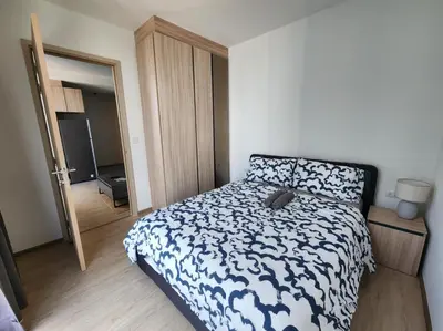 a bedroom with a bed with a black and white comforter at Thanon Phaya in Bangkok