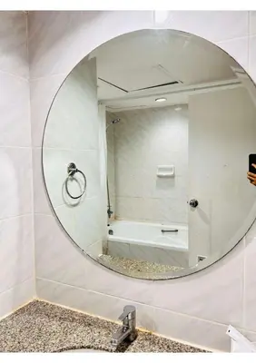 a bathroom mirror with a tub and a sink at Affordable Serviced Apartments in Nana Omni Tower - Prime Sukhumvit location in Bangkok