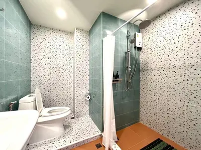 a bathroom with a toilet and a glass shower at DiscoveryHome4 at Pratunammarket in Bangkok