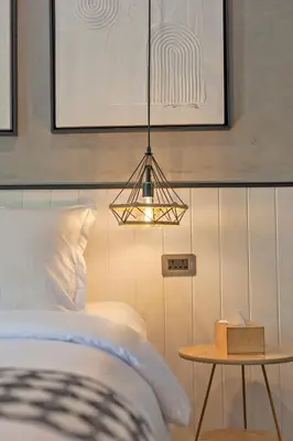 a bedroom with a bed and a table with a lamp at Chic loft in Bangkok