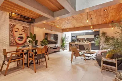 a living room with tables and chairs and a kitchen at Chic loft in Bangkok