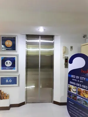 a elevator in a building with a sign next to it at Bed By City Hotel in Bangkok
