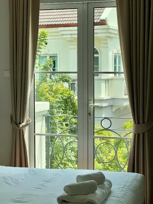 a bedroom with a bed and a sliding glass door at Entire 3BR Townhome in Sukhumvit, shared Pool, near BTS&MRT Asok in Bangkok