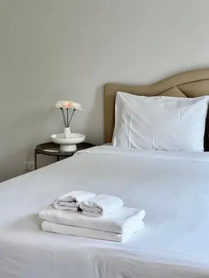 a white bed with two towels on it at Entire 3BR Townhome in Sukhumvit, shared Pool, near BTS&MRT Asok in Bangkok