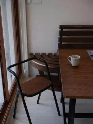 a wooden table and chair with a cup on it at Bedtime storeys near ICON SIAM in Bangkok