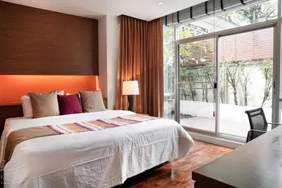 a bedroom with a large bed and a large window at Destiny55 Thonglor Apartment in Bangkok
