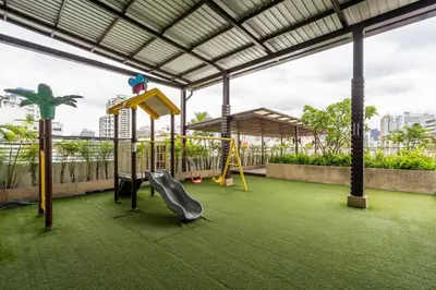 a play area with a slide and swings at Destiny55 Thonglor Apartment in Bangkok