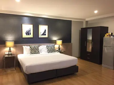 a bedroom with a large white bed with two lamps at Alt Hotel Nana by UHG in Bangkok