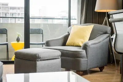 a chair and a ottoman in a living room at Alt Hotel Nana by UHG in Bangkok