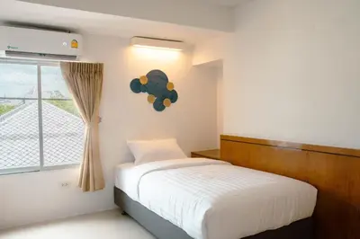a bedroom with a bed and a window at Alley & Pier in Bangkok