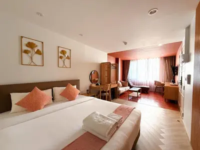 a bedroom with a large bed and a living room at SO Zen Hotel Silom Bangkok in Bang Rak