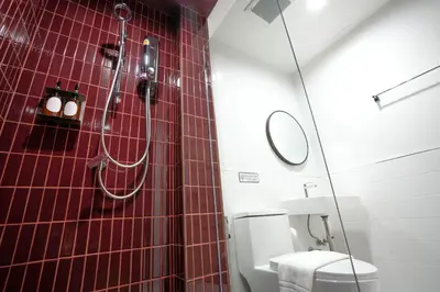 a red tiled bathroom with a toilet and a shower at SO Zen Hotel Silom Bangkok in Bang Rak