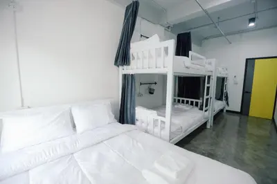 a white bedroom with two bunk beds in it at G5 Hostel in Bangkok