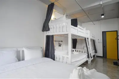 a bedroom with two bunk beds and a yellow door at G5 Hostel in Bangkok