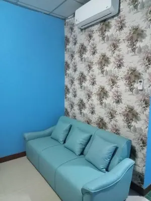 a blue couch in a room with a wall at Baan Sood Soi Residence 1 บ้านสุดซอย เรซิเด้นท์ 1 in Ban Bang Bamru