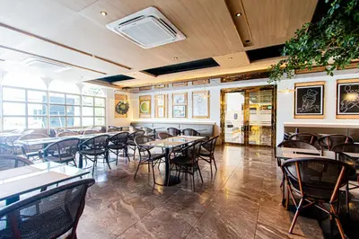 a restaurant with tables and chairs in a room at Frame Hotel Bangkok in Bangkok