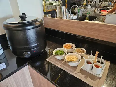 a table with bowls of food on a counter at Frame Hotel Bangkok in Bangkok