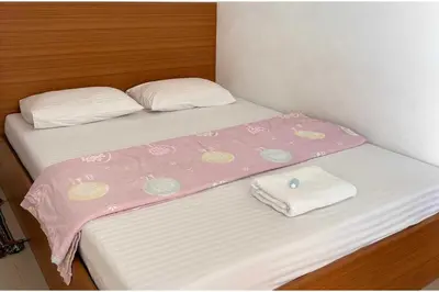 two beds with a pink and white blanket on them at OYO 75577 Palace Hostel in Amphoe Phra Khanong