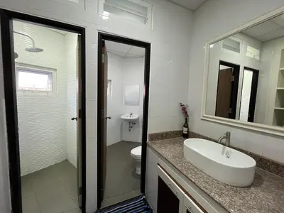 a bathroom with a sink and a toilet and a mirror at Dao Jaras Fah Hometel ดาวจรัสฟ้าโฮมเทล in Bangkok