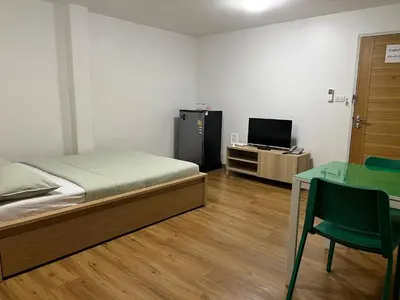 a bedroom with a bed and a desk and a television at Dao Jaras Fah Hometel ดาวจรัสฟ้าโฮมเทล in Bangkok