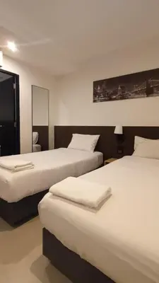 a hotel room with two beds and a mirror at The Blocks Hostel Sukhumvit 10 in Bangkok
