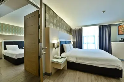a hotel room with two beds and a window at Prestige Suites Nana in Bangkok