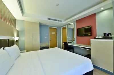 a hotel room with a large bed and a desk at Prestige Suites Nana in Bangkok