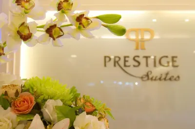 a display of flowers in front of a presence suites sign at Prestige Suites Nana in Bangkok