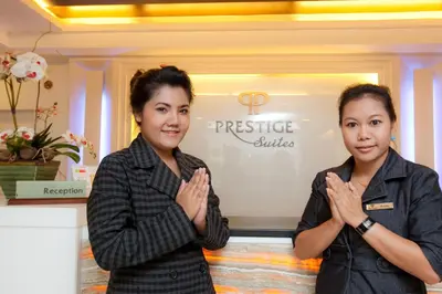 two women clapping their hands in front of a store at Prestige Suites Nana in Bangkok