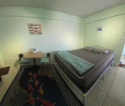 a bedroom with a bed and a table on a rug at 812 Quiet AC Apartment with Balcony & free Wifi in Bangkok