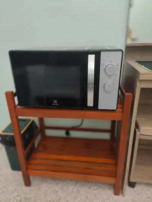 a microwave sitting on a wooden stand at 812 Quiet AC Apartment with Balcony & free Wifi in Bangkok
