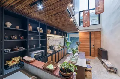 a kitchen with blue cabinets and a table with plants at Siam Shelter Bangkok in Bangkok