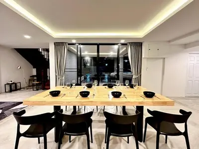 a large wooden table with chairs in a room at Number3 Poolvilla Bangkok in Lat Krabang
