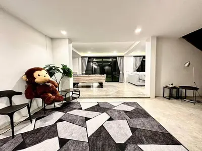 a teddy bear sitting on a chair in a living room at Number3 Poolvilla Bangkok in Lat Krabang