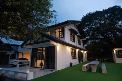 a white house with a bench in the yard at Number3 Poolvilla Bangkok in Lat Krabang