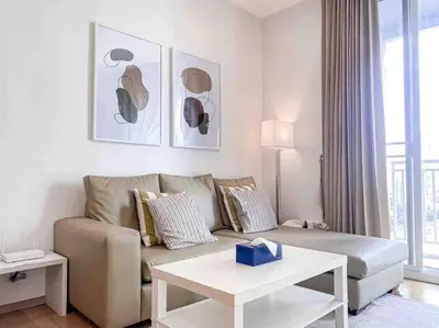a living room with a couch and a table at Expansive Modern - BTS Phrom Phong - Ultra Fast WiFi in Khlong Toei