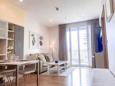 a living room with a couch and a table at Expansive Modern - BTS Phrom Phong - Ultra Fast WiFi in Khlong Toei