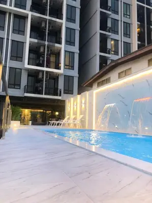 a swimming pool in front of a building at Marigold Sukhumvit - Free Shuttle to BTS Bearing Station in Bangkok