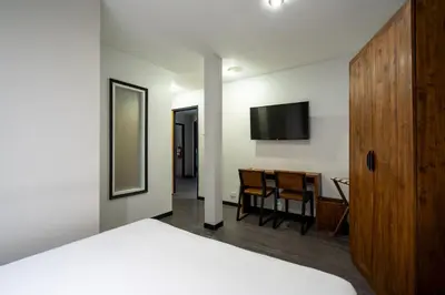 a bedroom with a bed and a desk and a television at XX GO INN Sukhumvit-Bts Asoke-Phrom Phong โกอินน์ สุขุมวิท in Bang Kapi